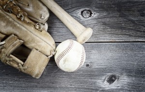 Vintage concept of old worn glove, bat and used baseball on rustic wood