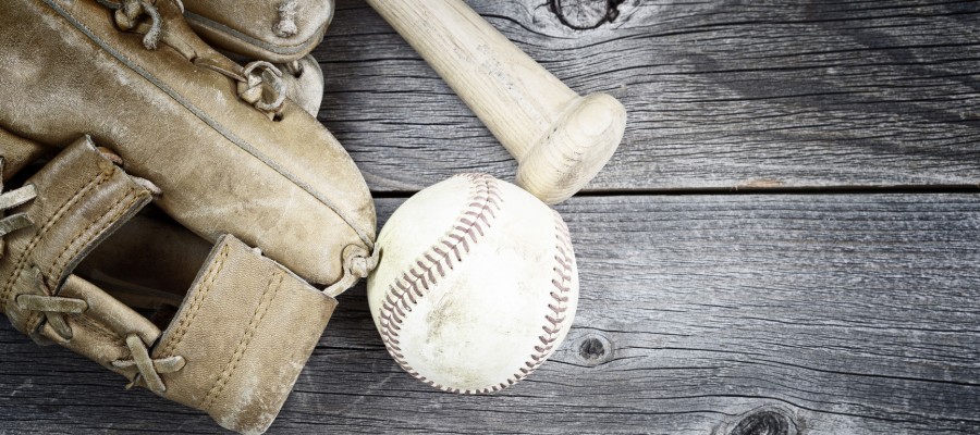Vintage concept of old worn glove, bat and used baseball on rustic wood